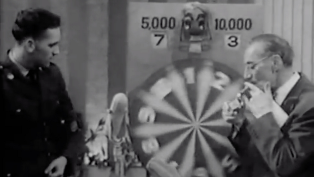 A You Bet Your Life contestant watches the spinning wheel while host Groucho Marx does not.